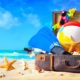 Beach accessories in suitcase on sand. Family holidays concept